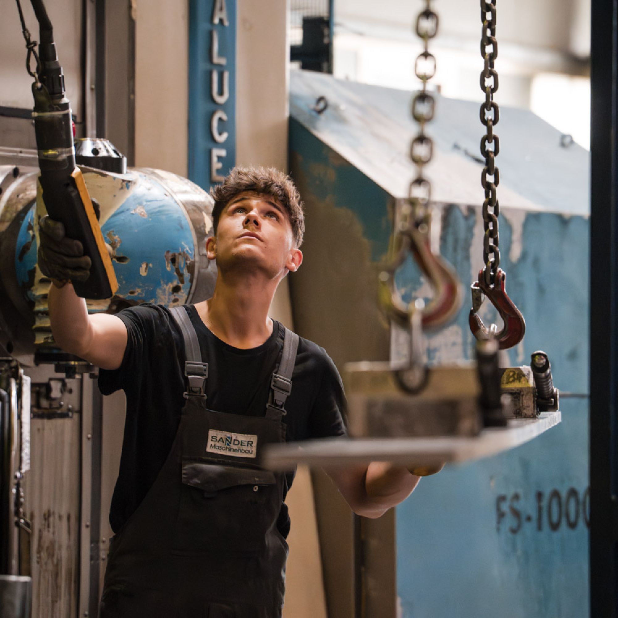 junger Mitarbeiter bedient Kran
