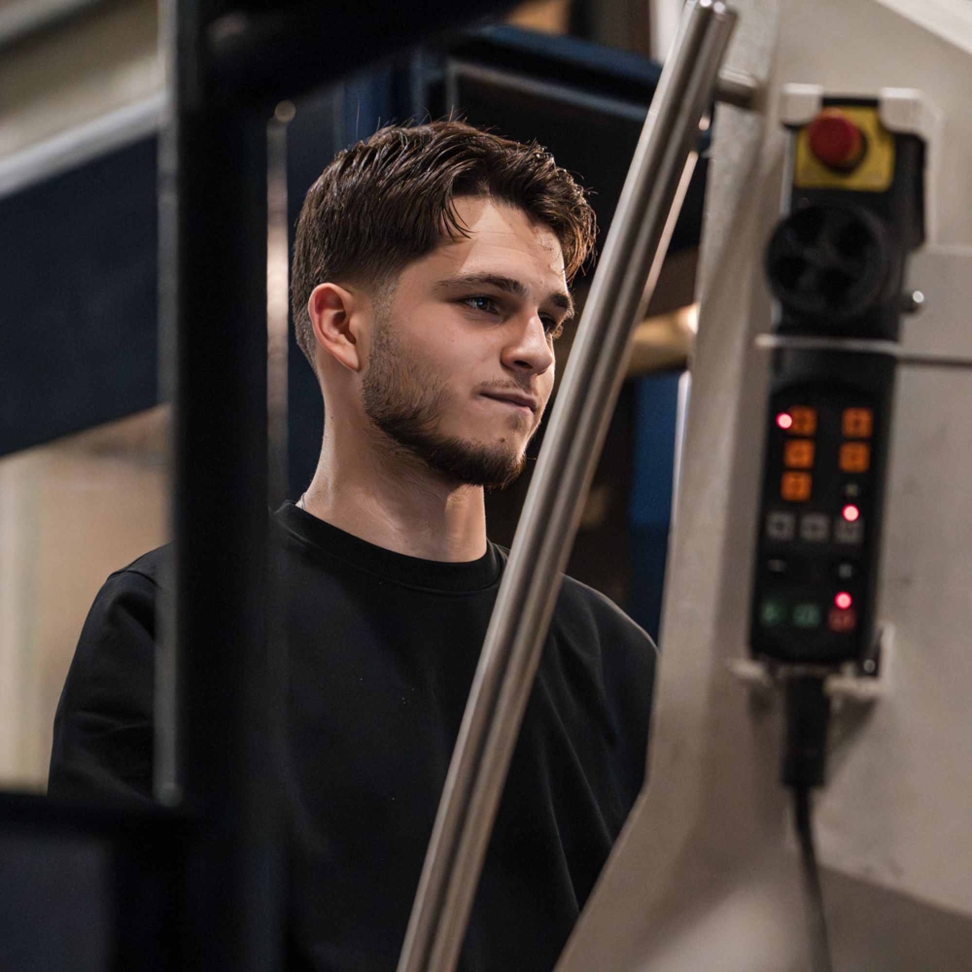 junger Mitarbeiter bedient Maschine